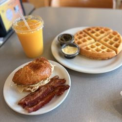 Cafe 108 - The Belgian Waffle, Orange Juice and Croissant Sausage Egg Cheese Breakfast Sandwich with a side of Bacon.
