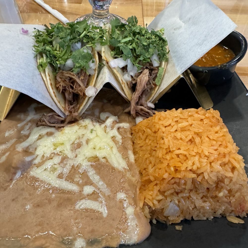 Carnitas tacos refried beans and Mexican rice and a delightful pina colada in the back! Carnitas tacos refried beans and Mexican rice and a delightful pina colada in the back!