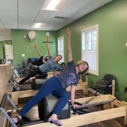Holly's Pilates Village - Practicing side-overs on the Pilates Reformer to strengthen and stretch core muscles.