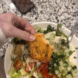 a bowl of salad with a piece of bread a bowl of salad with a piece of bread