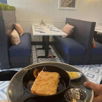 Our Mom Eugenia - Shirlington - Saganaki - flaming cheese with lemon, brandy - Greek Near Me - Arlington, Virginia Our Mom Eugenia - Shirlington - Saganaki - flaming cheese with lemon, brandy - Greek Near Me - Arlington, Virginia