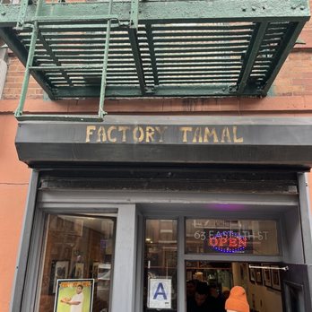 Factory Tamal - a woman standing in front of a store - Mexican Near Me - New York, New York Factory Tamal - a woman standing in front of a store - Mexican Near Me - New York, New York