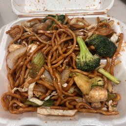 a take out container with noodles and broccoli