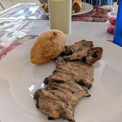 Pollito Con Papas - Chicken thigh with a chicken stuffed potato.