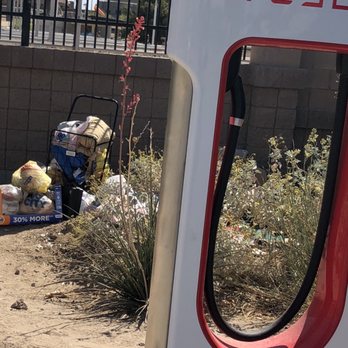 Tesla Supercharger - Homeless person's belongings are stashed away behind the chargers. - EV Charging Stations Near Me - Yuma, Arizona