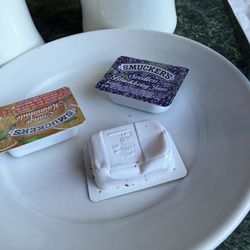 Brought out jam packets on a plate. It looks like it was scavenged from another plate, picked up off the floor- or both