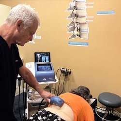 Kirstein Chiropractic & Shockwave Center - Dr. R. Todd Kirstein performing shockwave therapy on a patient's back