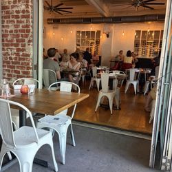 Oakhart Social Restaurant - Wooden tables with metal chairs inside and out.