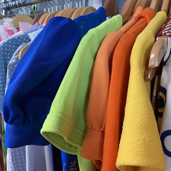 Lint - Vintage dresses and tops - Children's clothing in various bright colors, including blue, green, orange, and yellow, displayed on hangers in a store. - Men's Clothing Near Me - Corvallis, Oregon