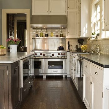 RM Home Improvements - a kitchen with white cabinets and stainless steel appliances - General Contractors Near Me