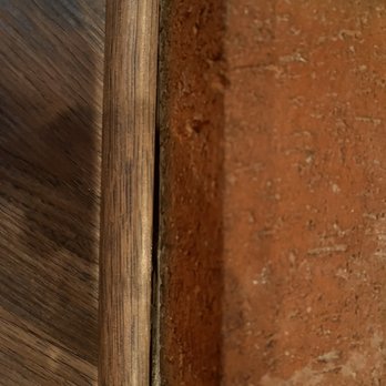 Ed's Floor & Home - Gap - A detailed close-up of a brick wall adjacent to a wooden surface, showing textures and colors of the materials. - Carpeting Near Me - Plaistow, New Hampshire