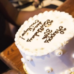 Tiara Cakes - Chocolate cake with strawberry jam layers, covered in white buttercream and decorated with gold sparkle and chocolate lettering.
