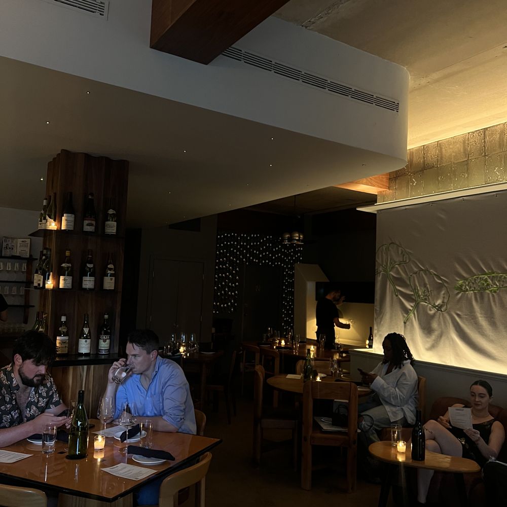 Parcelle - a group of people sitting at a table in a restaurant - Wine Bars Near Me - New York, New York