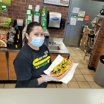 Skyway Travel Center - a woman in a face mask holding a hot dog - Gas Stations Near Me - Grants, New Mexico Skyway Travel Center - a woman in a face mask holding a hot dog - Gas Stations Near Me - Grants, New Mexico