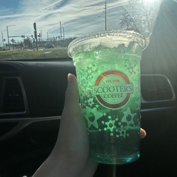 Scooter's Coffee - a hand holding a cup of green liquid - Coffee & Tea Near Me - Atlantic, Iowa Scooter's Coffee - a hand holding a cup of green liquid - Coffee & Tea Near Me - Atlantic, Iowa
