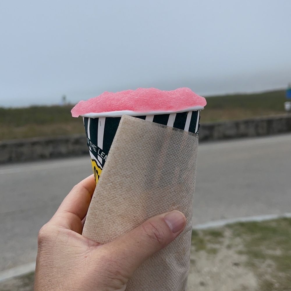 Dels Lemonade - a person holding a pink and black striped ice cream cone - Juice Bars & Smoothies Near Me - Newport, Rhode Island