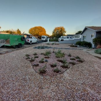 Green Spaces Landscaping - a gravel driveway with a flower bed in the middle - Landscaping Near Me Green Spaces Landscaping - a gravel driveway with a flower bed in the middle - Landscaping Near Me