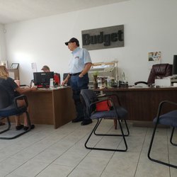 Budget Truck Rental - Joseph (standing) assisting his coworker better provide a customer with information on their rental.