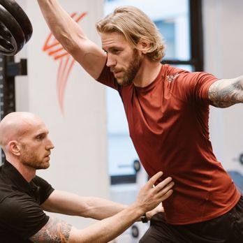 Zach Moore Personal Training - Form is critical, especially when you're pressing heavy weight over your head. Here I am cueing Paul to engage his core to protect his back. - Trainers Near Me - New York, New York Zach Moore Personal Training - Form is critical, especially when you're pressing heavy weight over your head. Here I am cueing Paul to engage his core to protect his back. - Trainers Near Me - New York, New York