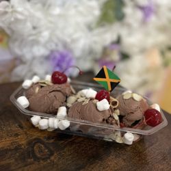 Scoop N Sip - Sundae- Chocolate Ice cream, slivered almonds, mini marsh-mellows, maraschino cherries, chocolate Pirouette, and a mini Jamaican Flag.