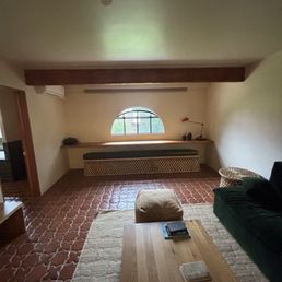 the living room area (with a tv and an armless couch)