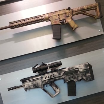 Rainier Arms - An AR and a Tavor on Rainier Arms' gun wall.  The Kryptek camo on the Tavor is particularly awesome. - Guns & Ammo Near Me - Auburn, Washington