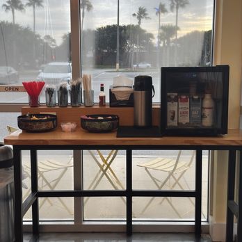 The Bodega - Bar area with condiments, different milks, and utensils - Breakfast & Brunch Near Me - Jacksonville Beach, Florida