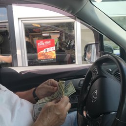 a man sitting in a car holding money a man sitting in a car holding money