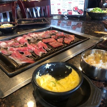 Let's Gogi - On the grill: brisket on the left, marinated sesame beef on the right Steamed egg and white rice on the tabletop. - Korean Near Me - Rowland Heights, California Let's Gogi - On the grill: brisket on the left, marinated sesame beef on the right Steamed egg and white rice on the tabletop. - Korean Near Me - Rowland Heights, California