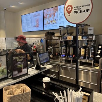 Peet's Coffee - Coffee with friends - A coffee shop interior features a counter with a sign indicating mobile order pickup, digital menu screens, and coffee brewing equipment. - Coffee & Tea Near Me - Chicago, Illinois