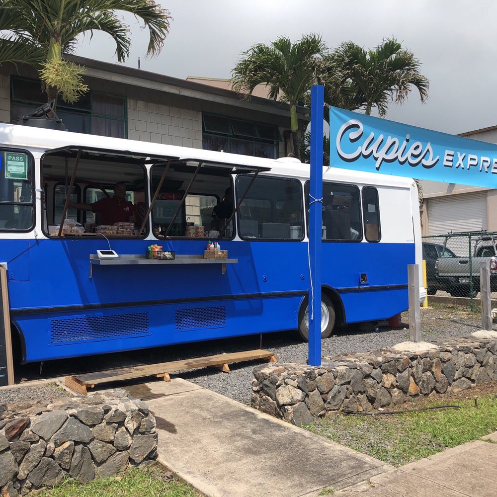 Cupies Express - a blue and white bus parked in front of a building - Food Trucks Near Me - Wailuku, Hawaii