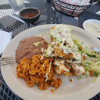 Poco & Moms - Gound beef chimichanga with sour cream green chili sauce over top. - American Near Me - Tucson, Arizona Poco & Moms - Gound beef chimichanga with sour cream green chili sauce over top. - American Near Me - Tucson, Arizona