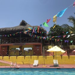 Paraiso Villa Guadalupe - Palapa restaurant and bar above with chairs by pool.