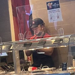 Employee not wearing mask properly and eating behind the line while serving customers