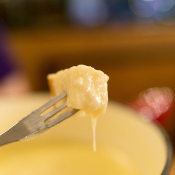Zebra Bar - A close up of bread, dipped in fondue. - Fondue Near Me - Zürich, ZH
