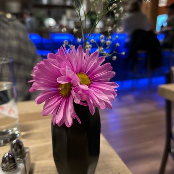 Outsider - a black vase with pink flowers on a wooden table - Bars Near Me - Spokane, Washington Outsider - a black vase with pink flowers on a wooden table - Bars Near Me - Spokane, Washington