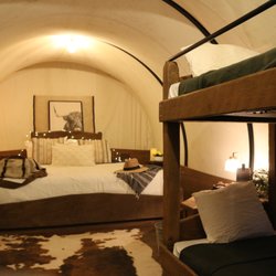 Sunny Valley Campground - Inside one of our two rentable wagons featuring a king sized bed, twin bunkbed, heat, outlets, lights, fire-pit and charcoal grill.