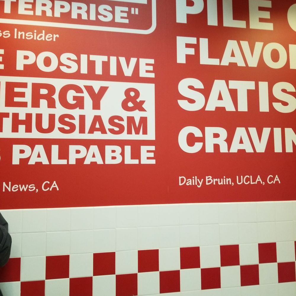 Five Guys - a man standing in front of a menu - Burgers Near Me - Greeley, Colorado Five Guys - a man standing in front of a menu - Burgers Near Me - Greeley, Colorado