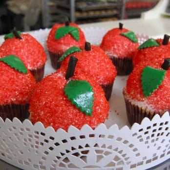 Cake-ology - a plate of cupcakes with red frosting and green leaves - Bakeries Near Me - Winnipeg, Manitoba