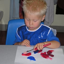 Small World Learning Center - Toddler painting during arts and crafts