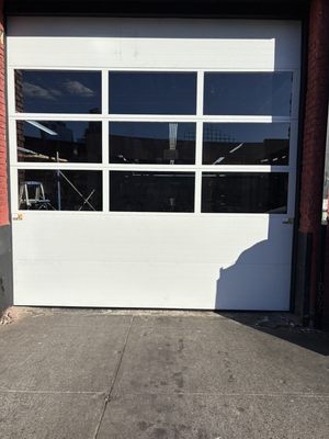 12x12 commercial door - We installed a special 12x12 commercial garage door with three sections of windows.
In the winter, it’s very cold and if you close the door, the client might think that the shop is close. That’s why we give him this special though with three section of windows. The client can see that there is workers that working at the body shop and the workers are warm because the door is closed in additional. We give him a special opener that they can open and close the door 100 times a day. 12x12 commercial door - We installed a special 12x12 commercial garage door with three sections of windows.
In the winter, it’s very cold and if you close the door, the client might think that the shop is close. That’s why we give him this special though with three section of windows. The client can see that there is workers that working at the body shop and the workers are warm because the door is closed in additional. We give him a special opener that they can open and close the door 100 times a day.