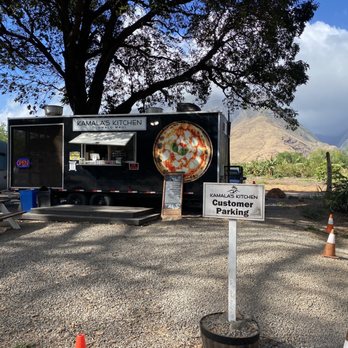 Kamala's Kitchen - a pizza truck with a sign in front of it - Pizza Near Me