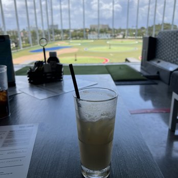 Drive Shack - a drink on a table with a baseball field in the background - Golf Near Me - West Palm Beach, Florida
