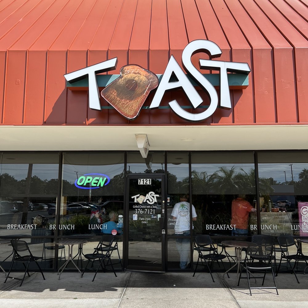 the front of a restaurant with tables and chairs the front of a restaurant with tables and chairs