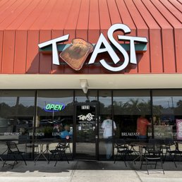 the front of a restaurant with tables and chairs the front of a restaurant with tables and chairs