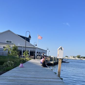 Dock House Restaurant - a woman sitting on a dock - Seafood Near Me - Chester, Maryland