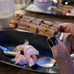 Pollos a La Brasa Mr Mario - Half eaten sweet and crispy/ soft centered churro. The gelato (ice cream was strawberry and a perfect pairing.