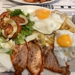 Oquendo - The grilled lomo with fried eggs, french fries and salad is a hearty dish.