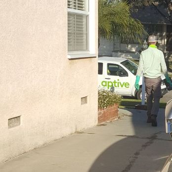 Aptive Pest Control - Technician (no name provided - license plate # 16712A2) getting chemical spray on 3 cars in driveway - Pest Control Near Me - Corona, California