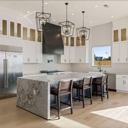 Urbatect Development - A chef's dream kitchen with marble countertops, custom cabinetry, and bold black accents.